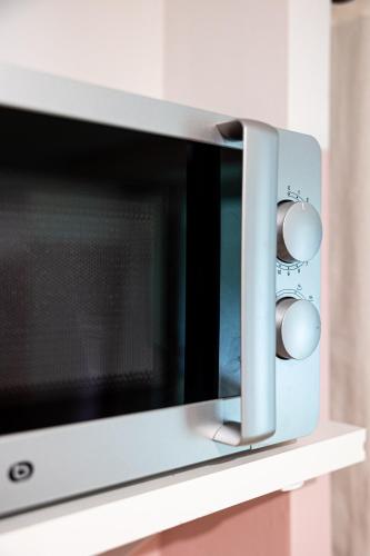un four micro-ondes installé au-dessus d'un comptoir dans l'établissement La vie en rose - appartement cosy - centre ville, à Auch