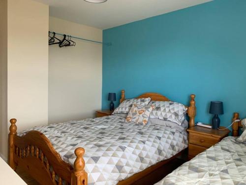 een slaapkamer met een bed en een blauwe muur bij Gortamaddy House in Ballycastle