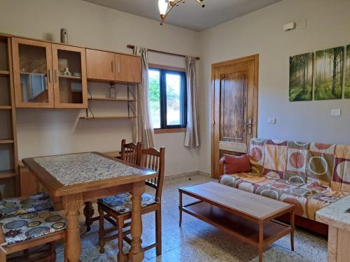 ein Wohnzimmer mit einem Tisch und einem Sofa in der Unterkunft Ás Portas do Sil - En la Ribeira Sacra 