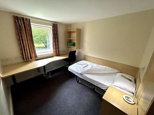 Zimmer mit einem Bett, einem Schreibtisch und einem Fenster in der Unterkunft Spacious Ensuite Room With Shared Kitchen and Living Room in Crewe