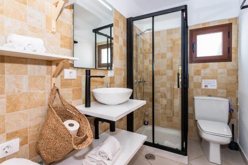een badkamer met een toilet, een wastafel en een douche bij Casa Volcán y Mar in Yaiza