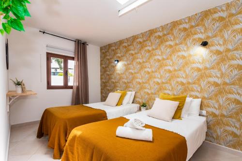 een hotelkamer met 2 bedden met gele lakens bij Casa Volcán y Mar in Yaiza