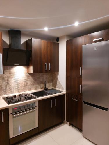 a kitchen with wooden cabinets and a stainless steel refrigerator at Coffee House in Gorzów Wielkopolski