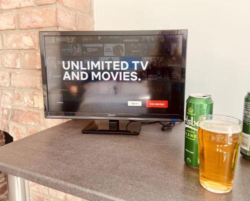 a television sitting on a table with a glass of beer at Martello Hotel in Hull