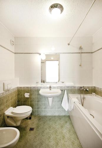 a bathroom with a toilet and a sink and a tub at Apartments Carrera in Sofia