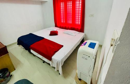 a small bedroom with a bed with a red window at Rose Garden home stay Thrissur in Trichūr