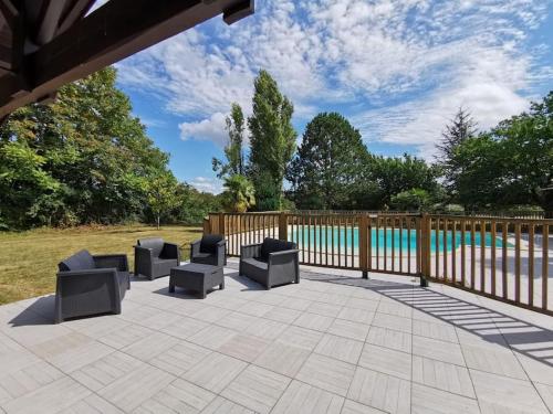 eine Terrasse mit Stühlen, einem Zaun und einem Pool in der Unterkunft Maison avec piscine 12m * 6m in Civrac-en-Médoc
