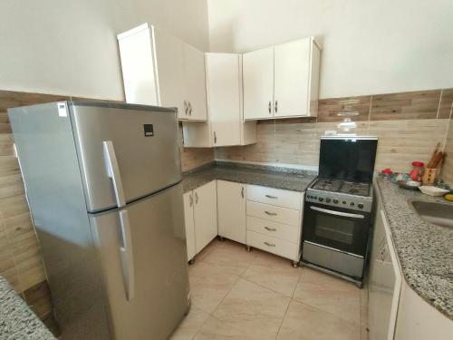 a kitchen with white cabinets and a stainless steel refrigerator at villa cleopatra in Luxor