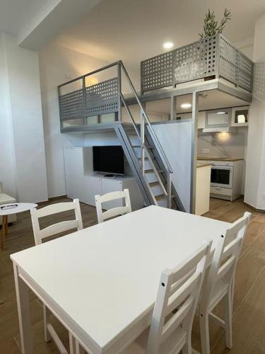 a room with a white table and chairs and a staircase at MiniLoft #Baiona / in Baiona