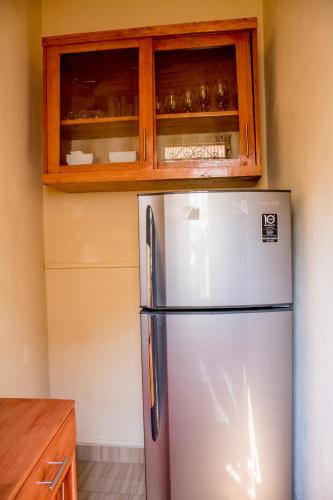 a kitchen with a stainless steel refrigerator and wooden cabinets at B I G Residence Hotel in Bujumbura