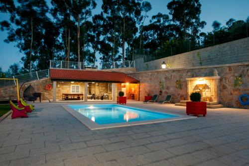 a swimming pool in a patio with a house at Casa do Sabugueiro in Ponte de Lima