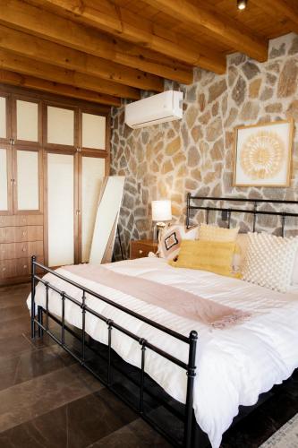 a large bed in a room with a stone wall at Casa de lujo, hasta con cine privado in San Miguel de Allende