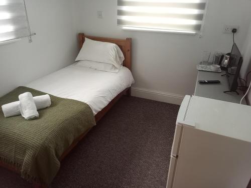a small bedroom with a bed and a desk at Martello Hotel in Hull