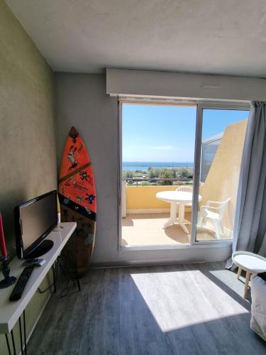 Habitación con escritorio, ordenador y ventana grande. en Sète vue mer linge fourni, en Sète