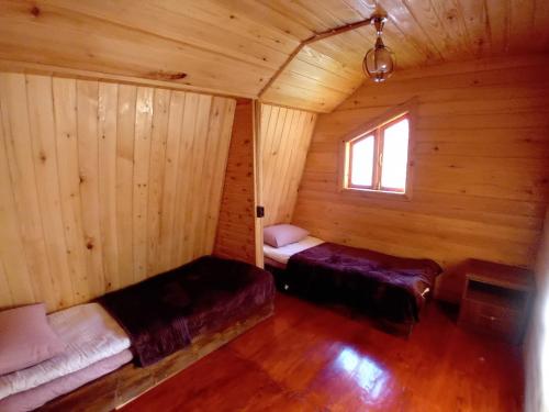 Habitación con 2 camas en una cabaña de madera en Wooden House in Tsvirmi en Tsvirmi