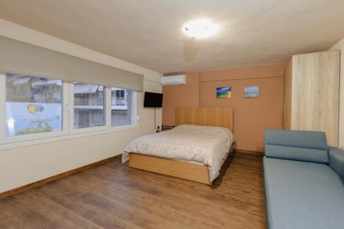 um quarto com uma cama, uma janela e um sofá em FAOS Properties em Kavala
