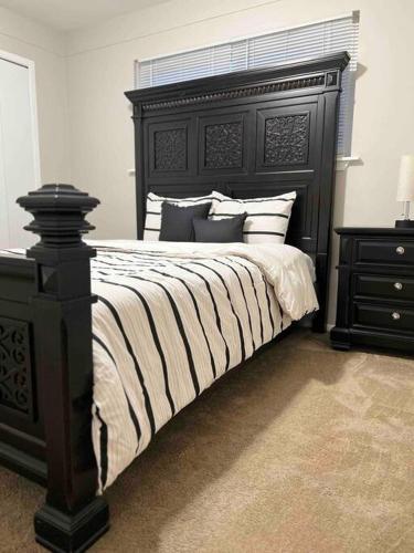 a bedroom with a large bed with a black headboard at Cozy Bungalow in Madison Heights in Madison Heights