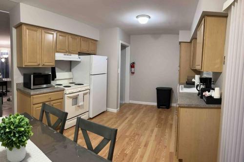 - une cuisine avec des appareils blancs et des armoires en bois dans l'établissement Cozy Bungalow in Madison Heights, à Madison Heights