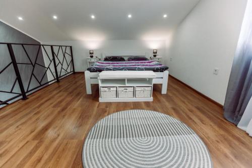 a bedroom with a bed and a rug on a wooden floor at Aria in Cetinje