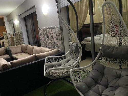 - un salon avec deux fauteuils et un canapé dans l'établissement Bel Appartement pour vacances, à Sidi Rahal