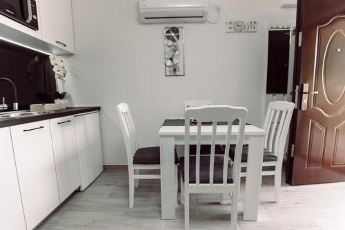 a white kitchen with a white table and chairs at Aria in Cetinje