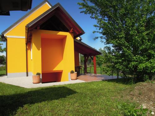 żółto-pomarańczowy dom z werandą w obiekcie Apartment Antonia w mieście Dobova