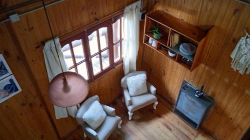 una vista aérea de una sala de estar con sillas y una ventana en Cabaña Aiken en Esquel