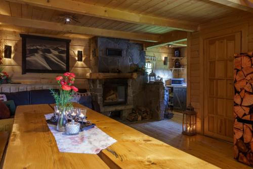 uma mesa de madeira num quarto com lareira em Leśna Bacówka em Nowy Targ