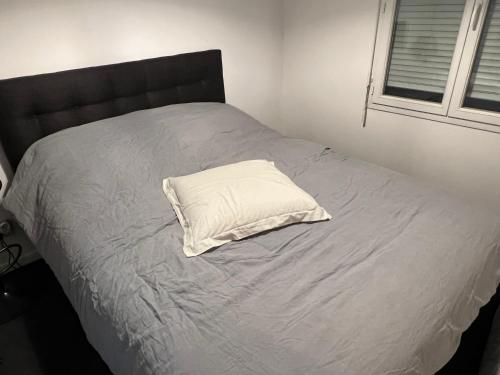 cuscino bianco posto sopra un letto di Appartement F2 a Longjumeau