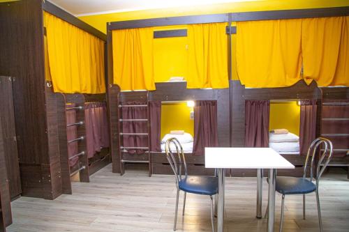 a room with yellow curtains and a table and chairs at Sun City Hostel 4 in Kyiv