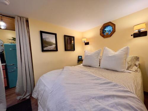 1 dormitorio con 1 cama grande con almohadas blancas en Dreamy Couples Cabin in the Shenandoah Forrest, en Luray