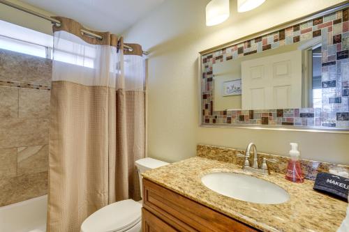a bathroom with a sink and a toilet and a mirror at Dog-Friendly Yard! North Phoenix Family Retreat in Phoenix