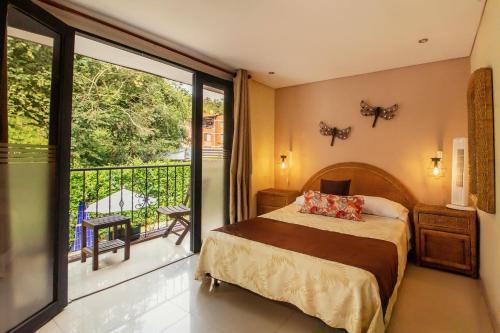 a bedroom with a bed and a balcony at Hotel El Ancla in La Vega