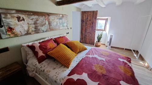 a bedroom with a bed with colorful pillows on it at Ca la Maria in Lilla