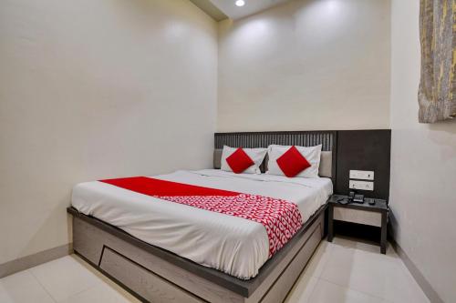 1 dormitorio con 1 cama grande con almohadas rojas en Hotel Dhiman Residency en Bombay