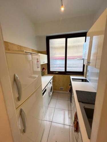 une petite cuisine avec un évier et une fenêtre dans l'établissement Jardin sur la Promenade des Anglais, à Nice