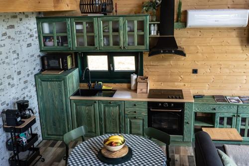 a kitchen with green cabinets and a table with bananas on it at River House Moon in Gospić