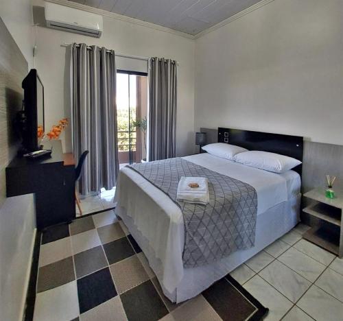 a bedroom with a large bed and a window at Hospedagem Domiciliar em Lucas do Rio Verde in Lucas do Rio Verde
