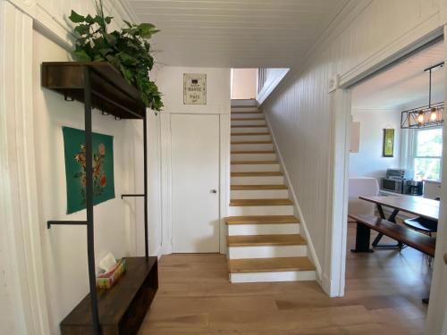 a staircase in a room with a desk and a table at Logement au Cœur du Village in Saint-Jean-Port-Joli