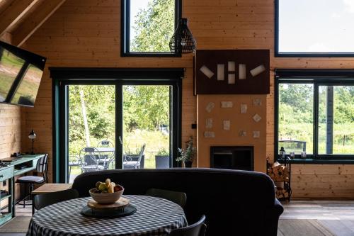 a living room with a table and some windows at River House Moon in Gospić