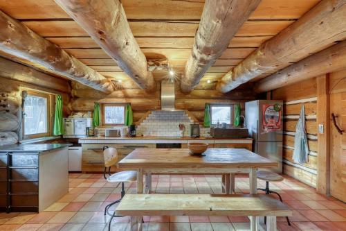 cocina con techos de madera, mesa y sillas en Chalet au bord d'un étang privé, Massif du Sancy, en Picherande