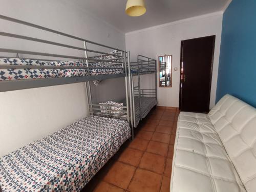 a bedroom with two bunk beds and a couch at Beach House Surfing Baleal Peniche in Baleal