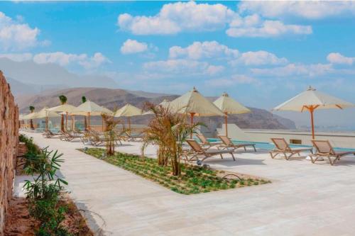 een groep stoelen en parasols op het strand bij Il monte galala -Ain El Sokhna in Ain Sokhna