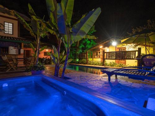 a swimming pool in front of a house at night at Pousada Atiaia in Ilhabela