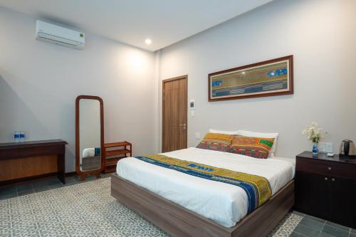 um quarto com uma cama, uma cómoda e um espelho em Villa De Pi's Hoi An em Hoi An