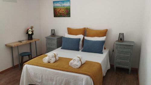 a bedroom with a bed with two towels on it at Casa do Geraço - Douro Guest House in Várzea do Douro