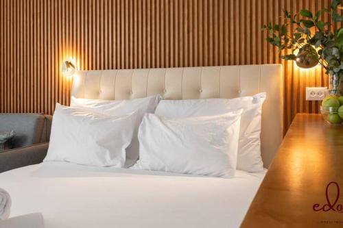 una camera da letto con un letto con cuscini bianchi e un tavolo di Luxury living 100 meter from the beach - by Edom a Eilat