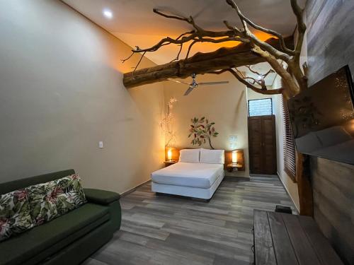 a bedroom with a white bed and a couch at Natura Reservado - Hoteles Natura in Anapoima