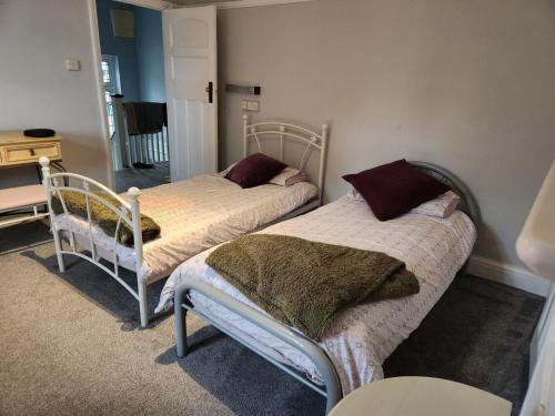 a bedroom with two beds and a table at Spacious Room with Garden in Croydon London in South Norwood