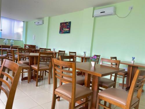 a dining room with wooden tables and chairs at Pousada Himura in Angra dos Reis